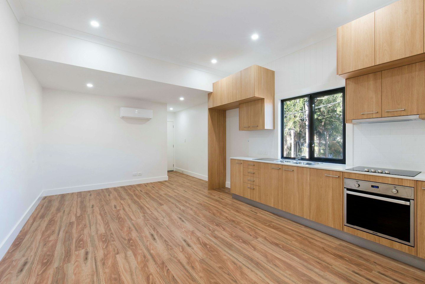 Newly renovated open-plan living room and kitchen with modern amenities.